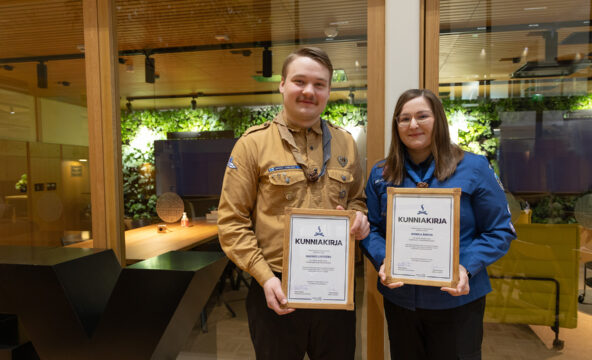Vuoden 2024 Toimivat partiojohtajat Rasmus Lindberg ja Monica Åhlman poseeraavat partiopaidat päällä pidellen kehystetettyjä kunniakirjoja.