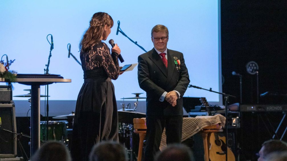 Iiro Lindberg vastaanottamassa Suomen Partiolaisten kultaista ansioristiä Siiri Somerkorolta.