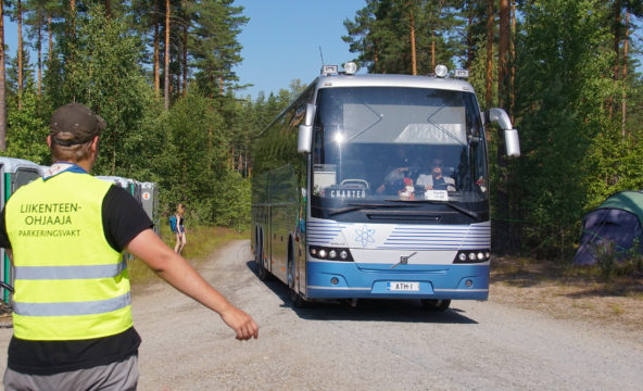 Liikenteenohjaaja ohjaamassa bussia Ilves19-piirileirillä